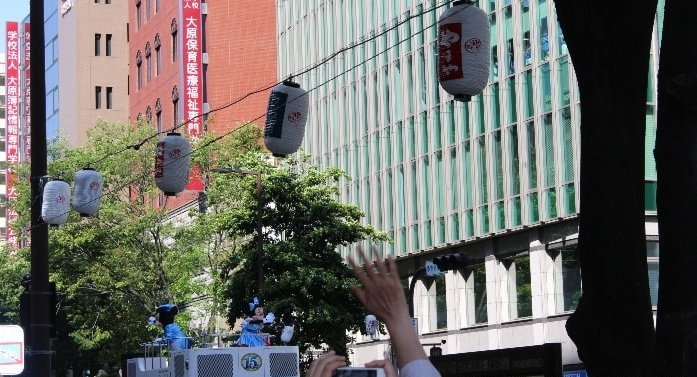 博多どんたくのパレードで周りに手を振るミッキーとミニー